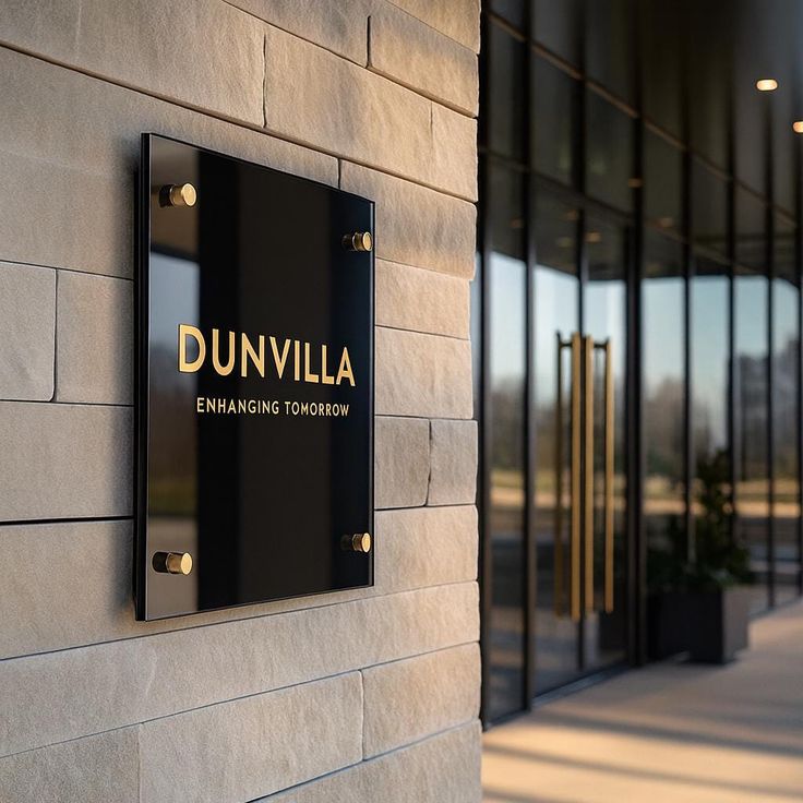 Custom Office Acrylic Sign _ Business Logo Wall Plaque _ Modern Company Signage for Reception Lobby Door Building exterior with Dunvilla sign on a stone wall, featuring modern architecture and a reflective glass entrance. | Sky Rye Design Building exterior with Dunvilla sign on a stone wall, featuring modern architecture and a reflective glass entrance.