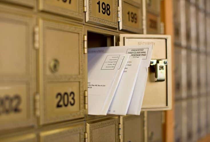Difference Between Physical PO Box and Online PO Box - PostScan Mail Mail envelopes peek out from an open post office box in a row of brown numbered mailboxes, indicating mail delivery. | Sky Rye Design Mail envelopes peek out from an open post office box in a row of brown numbered mailboxes, indicating mail delivery.