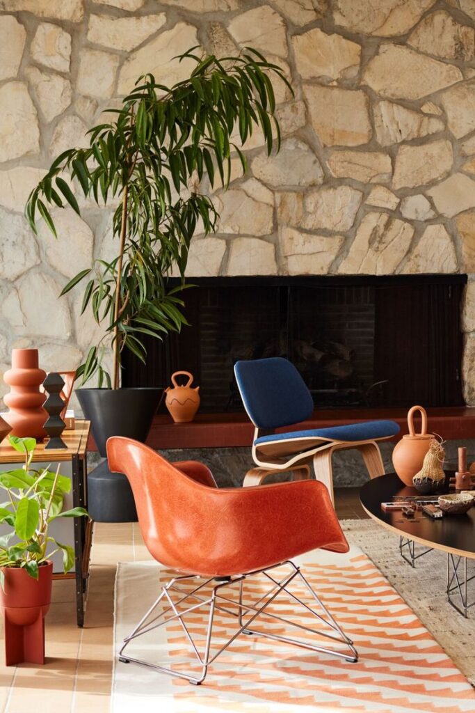 Discover A Curated Life Modern living room with stone wall, stylish chairs, indoor plants, and decorative items, creating a cozy and contemporary space. | Sky Rye Design Modern living room with stone wall, stylish chairs, indoor plants, and decorative items, creating a cozy and contemporary space.