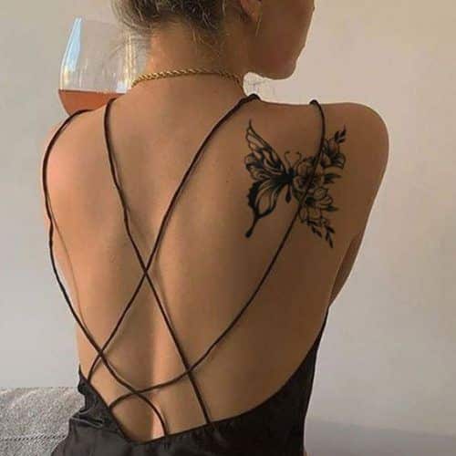 Discover the Top 15 Butterfly Back Tattoo Designs for 2025 Inspiring Art for Your Journey Back view of a woman with a floral butterfly tattoo on her shoulder, wearing a strappy black dress while holding a glass of rosé wine. | Sky Rye Design Back view of a woman with a floral butterfly tattoo on her shoulder, wearing a strappy black dress while holding a glass of rosé wine.