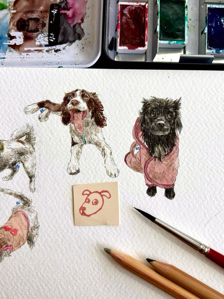 Colorful dog illustrations on paper with paint palette and brushes, showcasing artistic creativity and pet portrait art supplies.