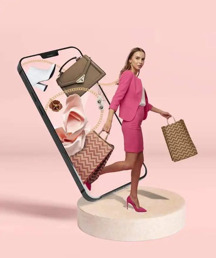 Woman in pink suit steps out of phone with shopping bags, surrounded by shoes, bags, and accessories on a pastel pink background.