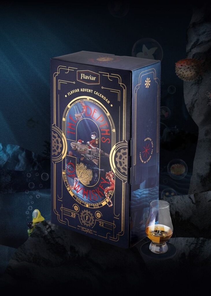 Luxurious Flaviar whiskey advent calendar with deep ocean theme beside a glass of whiskey on a dark, underwater background.