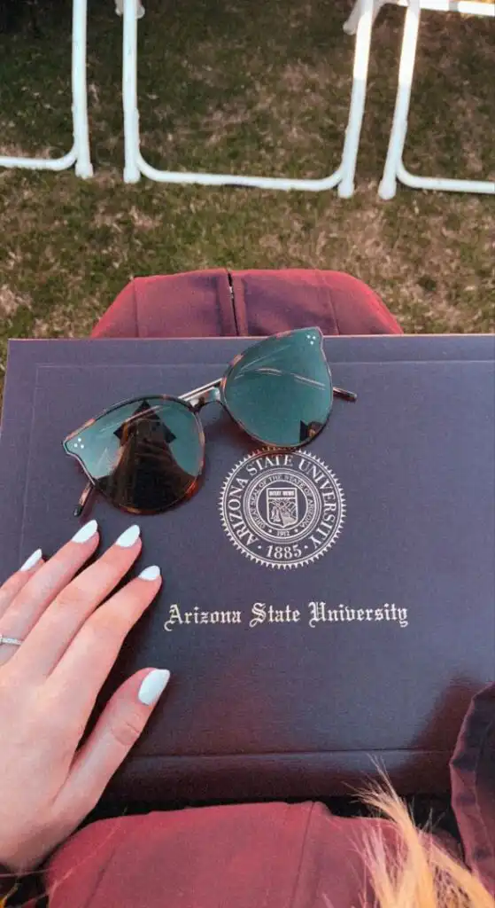 Graduation day at Arizona State University, diploma with sunglasses on top, celebrating academic achievement.