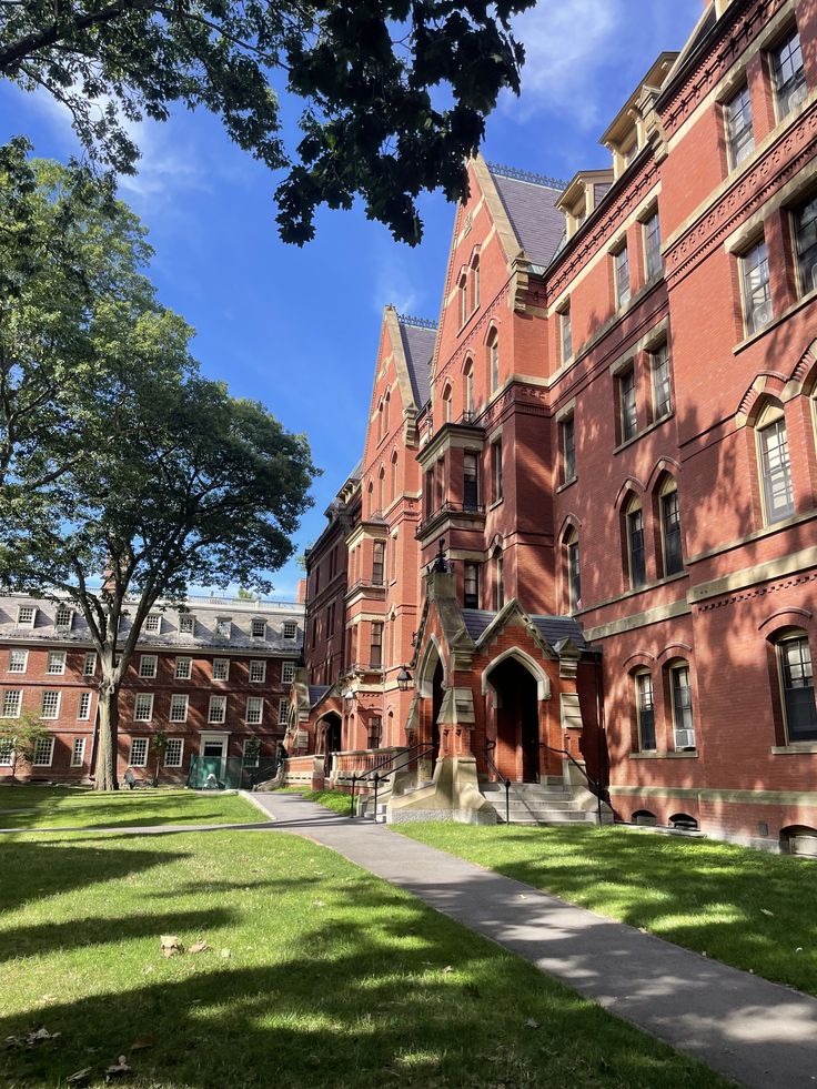 Harvard Historic red-brick university building under a clear blue sky, surrounded by lush green lawn and trees, reflecting classic architecture. | Sky Rye Design Historic red-brick university building under a clear blue sky, surrounded by lush green lawn and trees, reflecting classic architecture.