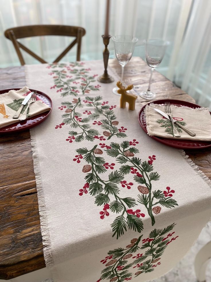 Holly and Pine Cotton Handprinted Table Runner Christmas Table Linen Thanksgiving Dinner Decor - Etsy UK Festive table setting with pine and berry runner, elegant glassware, and napkins featuring holiday designs on a rustic wooden table. | Sky Rye Design Festive table setting with pine and berry runner, elegant glassware, and napkins featuring holiday designs on a rustic wooden table.