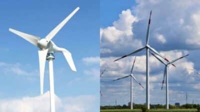 Two wind turbines against a blue sky with clouds, generating renewable energy in a field. Sustainable and eco-friendly technology.