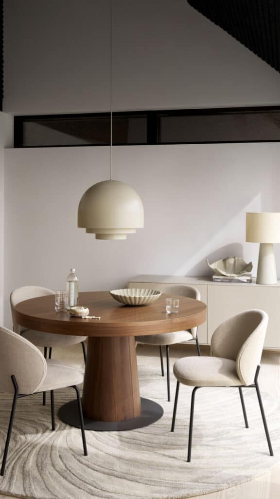 Modern dining room with round wooden table, beige chairs, and dome pendant light, creating an elegant, minimalist interior design.