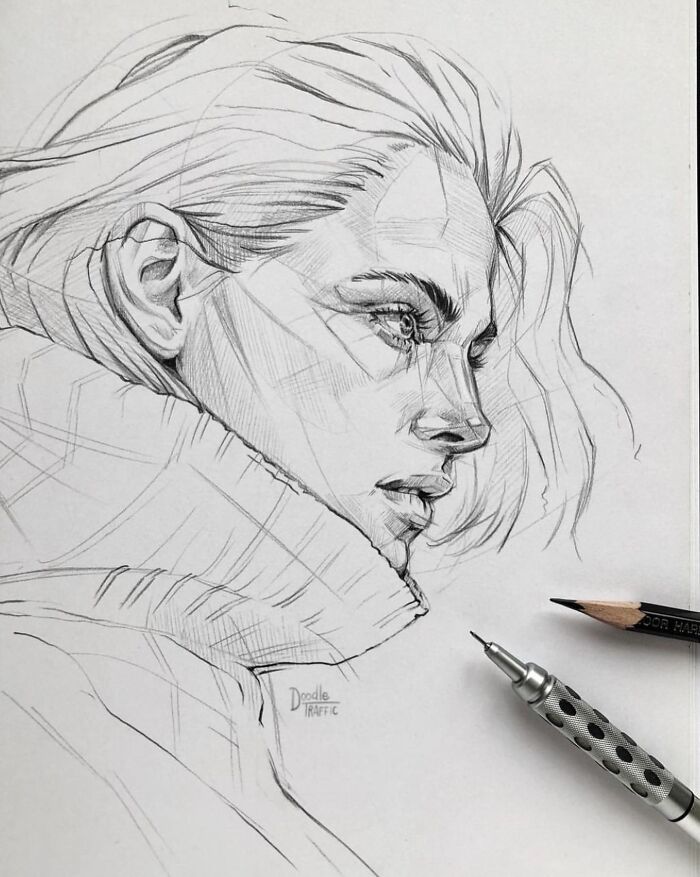 Pencil sketch of a woman's profile with flowing hair and detailed features, alongside a pencil and mechanical pencil on paper.