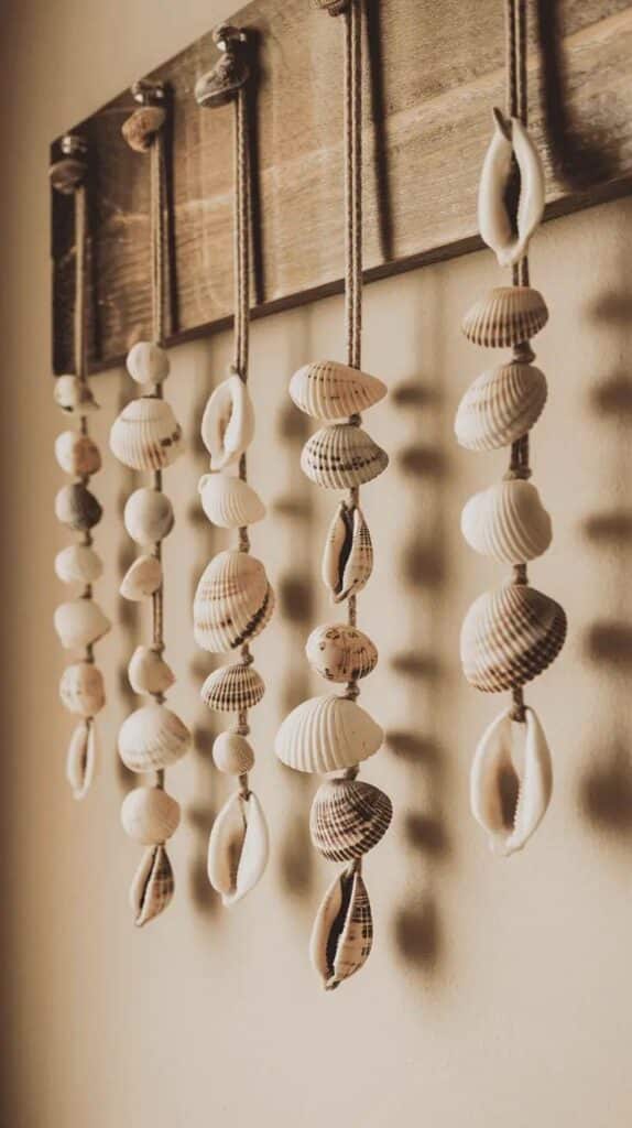 Hanging seashell decoration on a wooden rack against a beige wall for coastal-themed home decor inspiration.