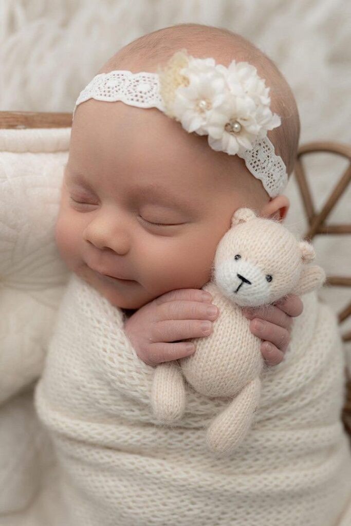 Ivory cream baby headbandDainty headbandFloral baby headbandNewborn ivory headbandCream photo prop headband Sleeping baby in white headband cuddling a knitted teddy bear, wrapped in a soft blanket. Cozy and peaceful newborn portrait. | Sky Rye Design Sleeping baby in white headband cuddling a knitted teddy bear, wrapped in a soft blanket. Cozy and peaceful newborn portrait.