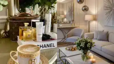 Luxury living room with Chanel and Louis Vuitton products on table, designer decor, elegant sofa, and coffee cup in chic setting.