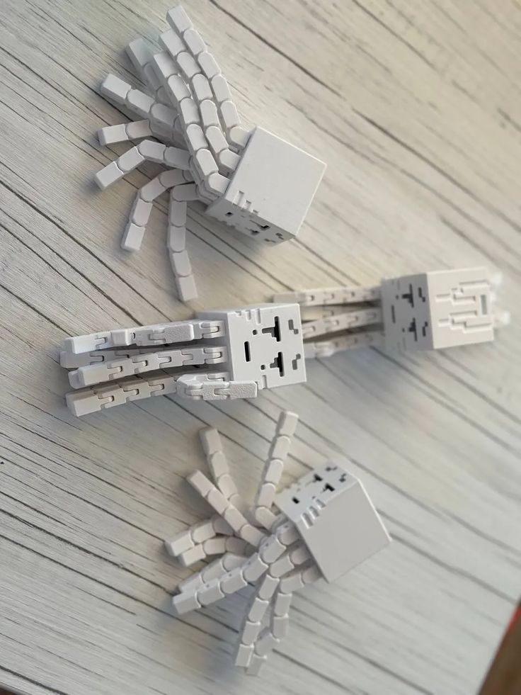 Minecraft Ghast Tentacles Articulated - Free 3D Print Model - MakerWorld Three white block-shaped octopus toys with articulated legs on a wooden surface. | Sky Rye Design Three white block-shaped octopus toys with articulated legs on a wooden surface.