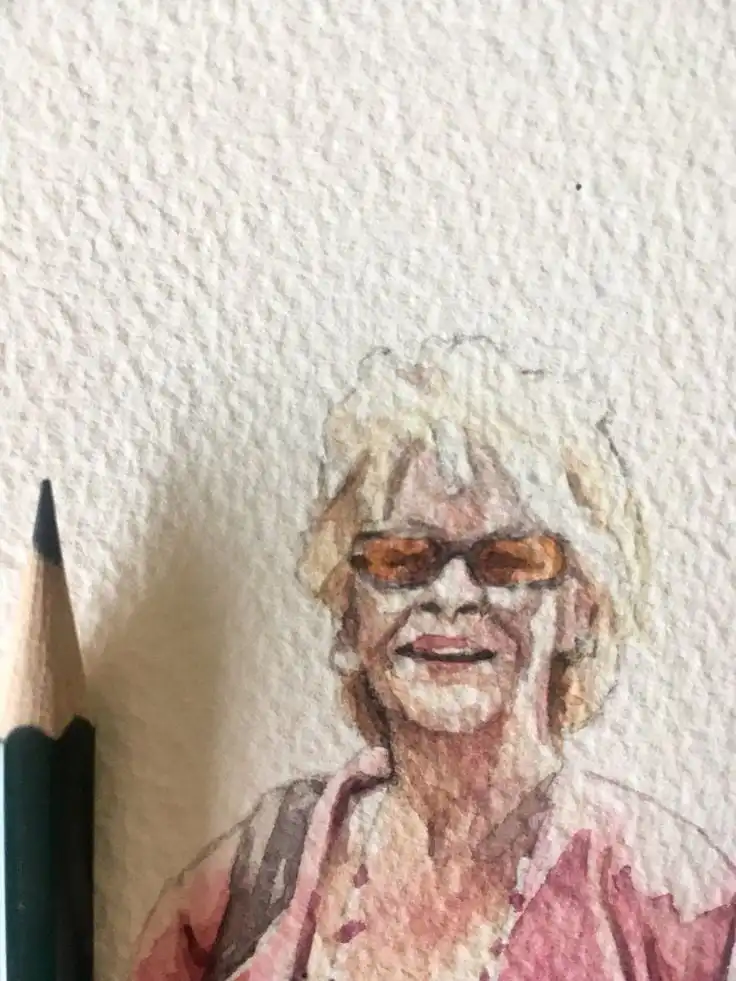 Watercolor portrait of a woman with sunglasses beside a pencil on textured paper.