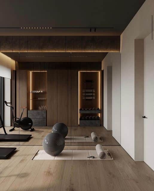 Minimalist Pleasure Magazine on Instagram_ _What a perfect space created by hilight_design gymplacearchitectureminimalismdesignarchitecturedesigninteriorperfecthomearchidailyminimalistelegantspace_ Modern home gym with exercise bikes, yoga mats, and fitness balls, featuring wooden accents and ambient lighting for a sleek workout space. | Sky Rye Design Modern home gym with exercise bikes, yoga mats, and fitness balls, featuring wooden accents and ambient lighting for a sleek workout space.