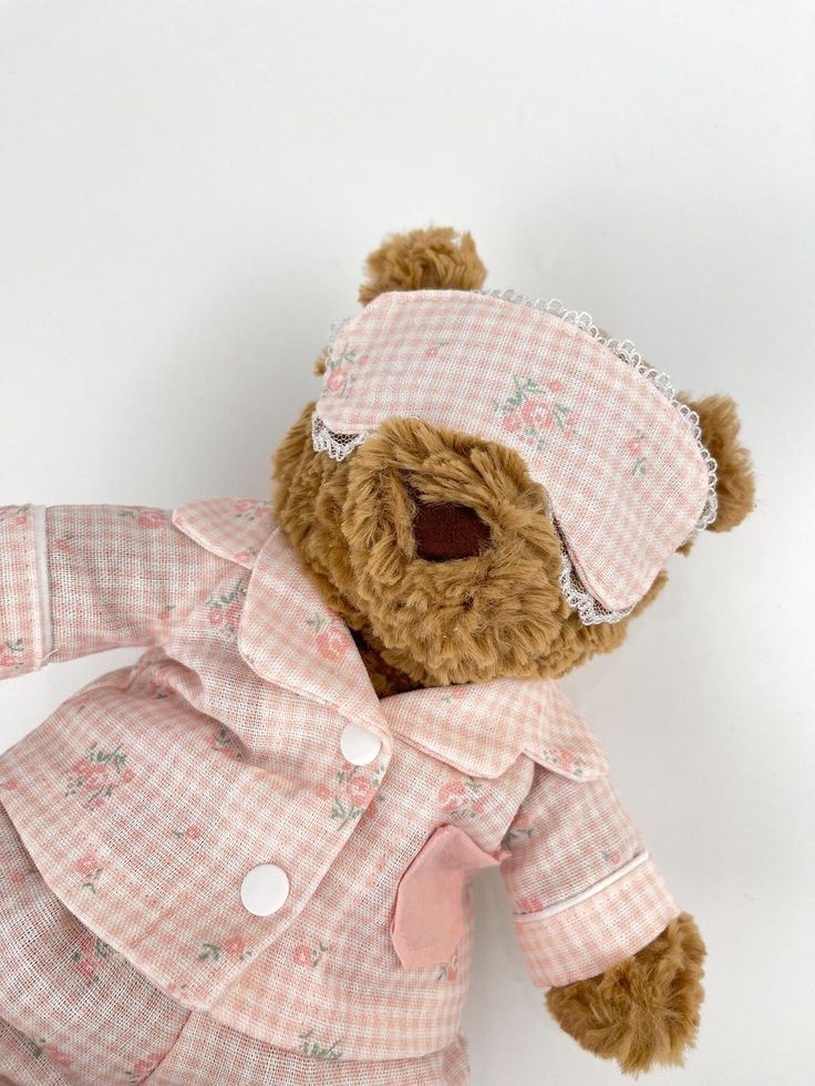 Cute teddy bear in pink floral pajamas and matching sleep mask, ready for bedtime. Cozy plush toy perfect for snuggling and gifts.