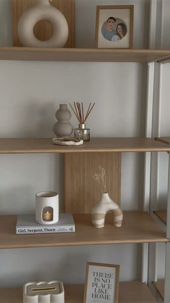 Neutral shelf styling with cozy decor pieces 🤍 Modern wooden shelf with vases, framed photo, reed diffuser, and decor books, creating a cozy, minimalist home atmosphere. | Sky Rye Design Modern wooden shelf with vases, framed photo, reed diffuser, and decor books, creating a cozy, minimalist home atmosphere.