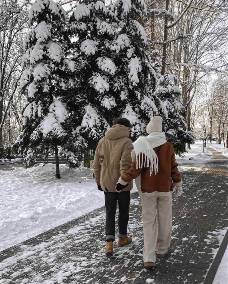 Nicholas and Naomi A couple strolls hand in hand on a snowy path, surrounded by snow-covered trees, during a serene winter day. | Sky Rye Design A couple strolls hand in hand on a snowy path, surrounded by snow-covered trees, during a serene winter day.