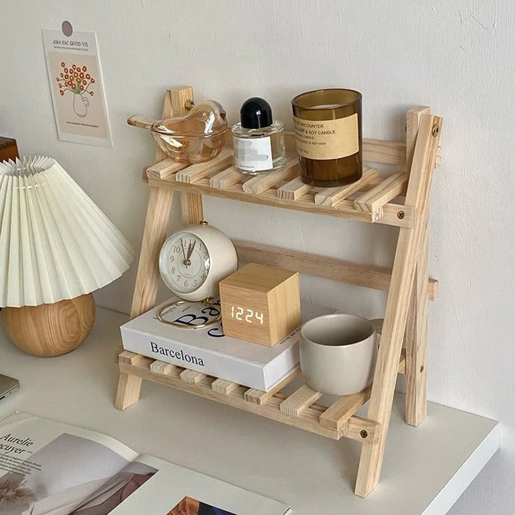 Wooden shelf with decor items: candle, clock, digital clock, book, lamp, and cup. Modern home organization and minimalist design.