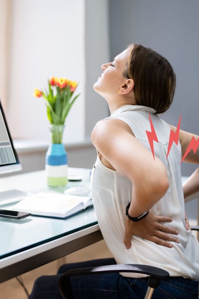 Our joints click louder than remotes Woman experiencing back pain at desk with flowers in background, highlighting ergonomic issues; office discomfort illustration. | Sky Rye Design Woman experiencing back pain at desk with flowers in background, highlighting ergonomic issues; office discomfort illustration.