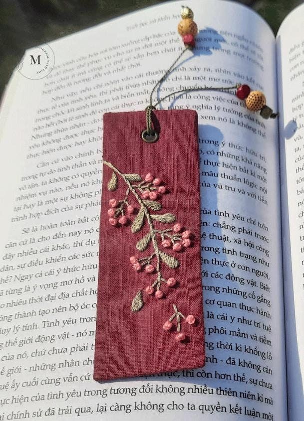 Personalized Bookmark Christmas Reindeer Hand Embroidered Custom Name Handmade Linen Bookmark Holiday Gift for Reader Gifts Book Lovers Embroidered floral bookmark with beads on an open book with Vietnamese text, blending craftsmanship with literary charm. | Sky Rye Design Embroidered floral bookmark with beads on an open book with Vietnamese text, blending craftsmanship with literary charm.