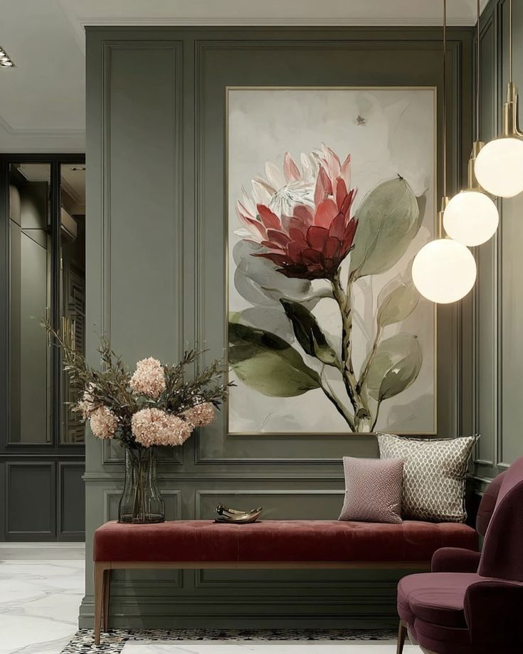 Elegant room with floral art, red bench, and beige-green walls. Cozy seating with stylish cushions and pendant lighting for a chic interior.