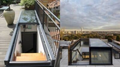 Rooftop view showing a modern glass hatch stairway leading to a scenic urban panorama under a cloudy sky.