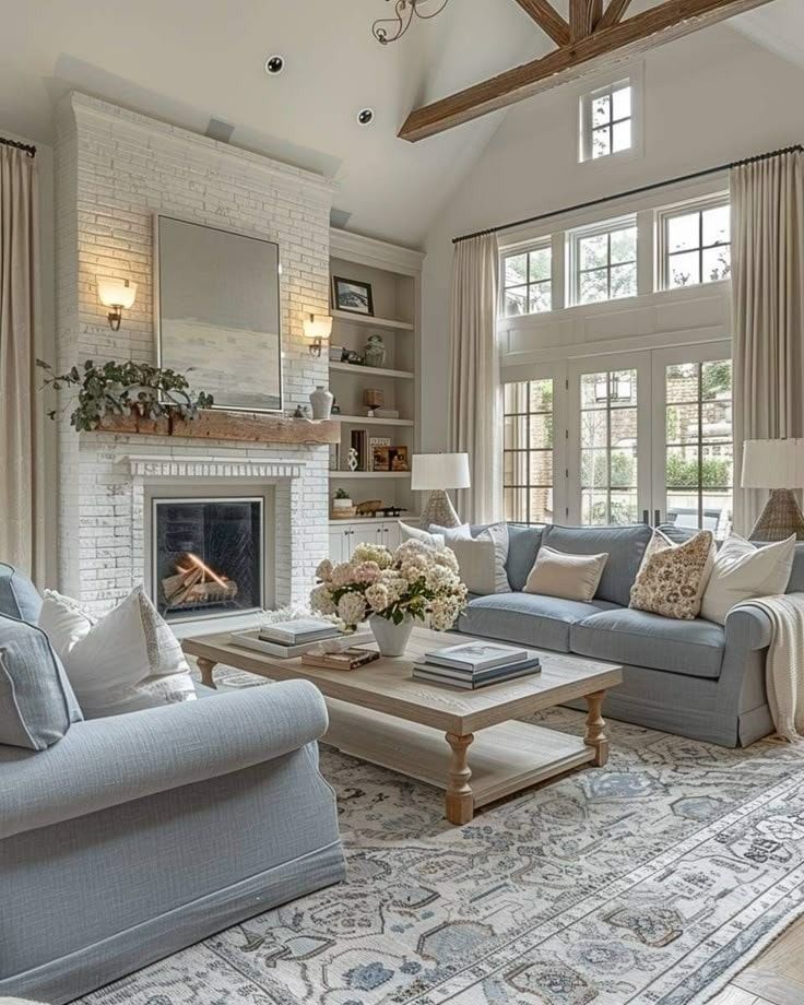 Rose Amsterdam II - Wow So beautiful ❤️❤️❤️ _ Facebook Elegant living room with cozy fireplace, large windows, blue sofas, and rustic beams. Bright and inviting design with floral accents. | Sky Rye Design Elegant living room with cozy fireplace, large windows, blue sofas, and rustic beams. Bright and inviting design with floral accents.
