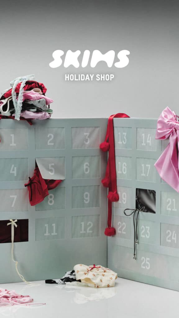 Advent calendar with lingerie gifts, featuring red, black, and white pieces. SKIMS Holiday Shop logo at the top.