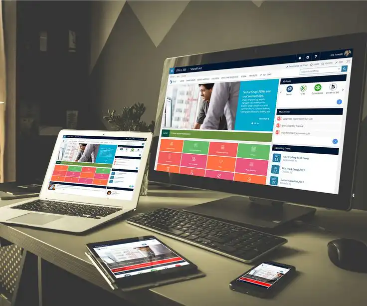 Multiple devices displaying Office 365 SharePoint dashboard, featuring colorful tiles and widgets, on a desktop, laptop, tablet, and smartphone.
