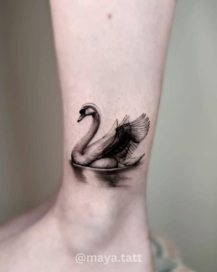 Swan tattoo micro realism maya_tatt Elegant swan tattoo on a leg showcases detailed black and gray shading, highlighting artistic intricacy and graceful design. | Sky Rye Design Elegant swan tattoo on a leg showcases detailed black and gray shading, highlighting artistic intricacy and graceful design.
