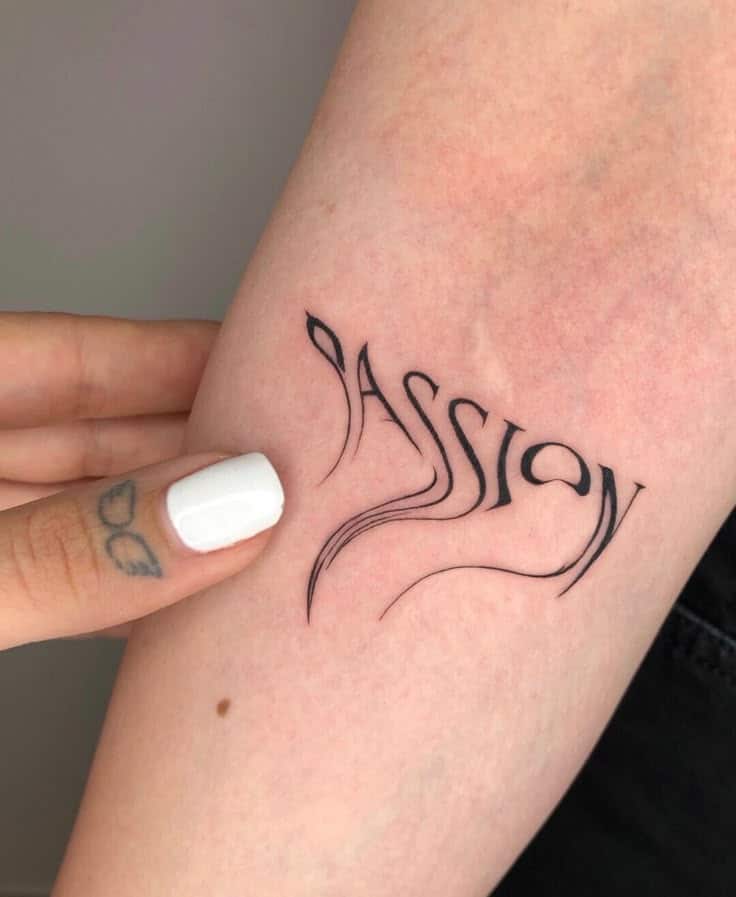 Stylish 'Passion' tattoo on arm, black ink, flowing script design, held by hand with white painted nails for artistic touch.