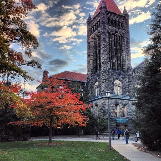 The most photogenic places in C-U part one - Historic stone tower with red autumn tree at university campus against a blue sky, students walking by. | Sky Rye Design Historic stone tower with red autumn tree at university campus against a blue sky, students walking by.