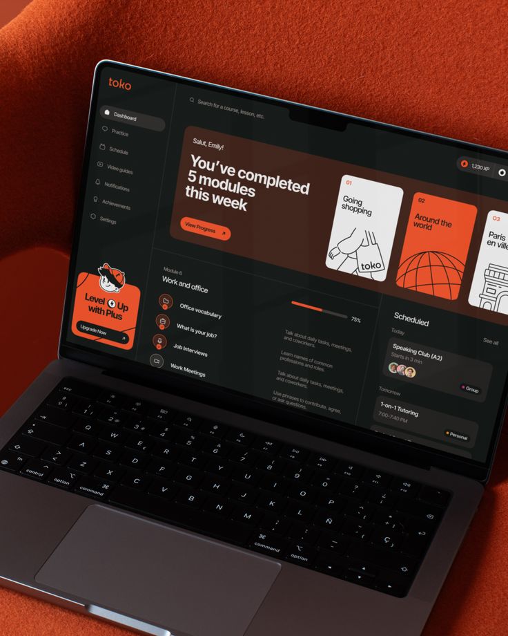 Laptop showing an app dashboard with learning modules and progress tracker in an educational platform interface.