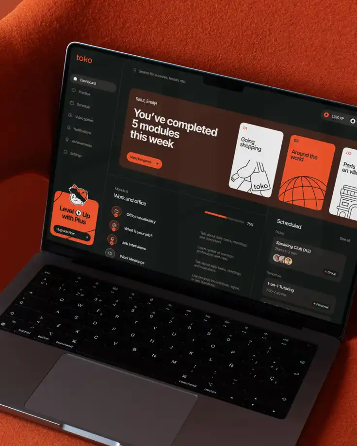 Laptop showing an app dashboard with learning modules and progress tracker in an educational platform interface.