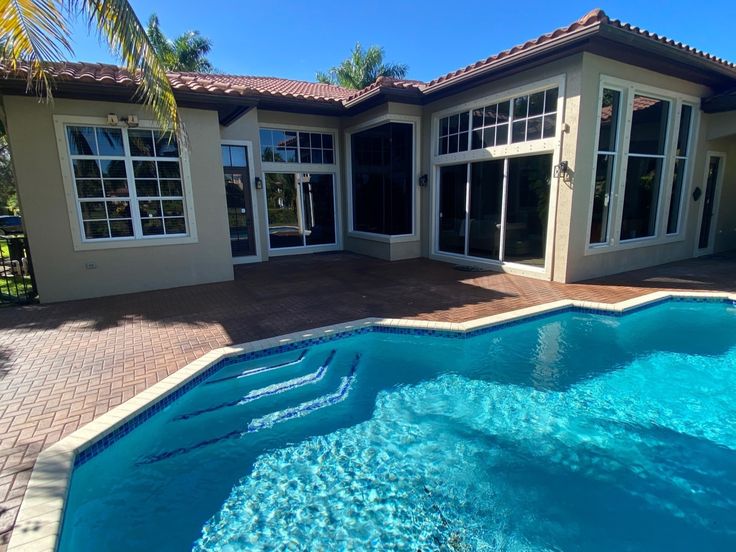 Top 10 Pool Vacuum Cleaners for Effortless Maintenance - GGR Home Inspections Luxurious modern home with large windows overlooking a sparkling blue swimming pool and sunlit patio, surrounded by tropical greenery. | Sky Rye Design Luxurious modern home with large windows overlooking a sparkling blue swimming pool and sunlit patio, surrounded by tropical greenery.