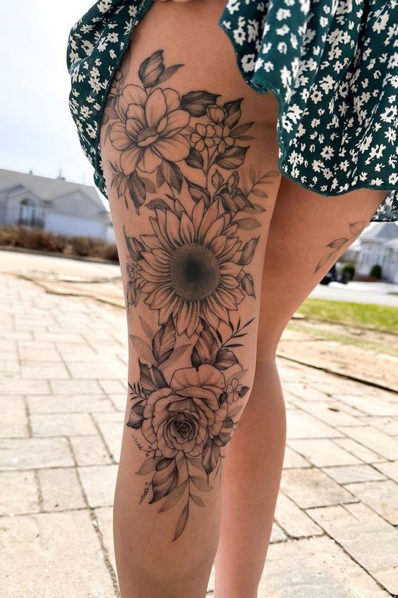 Unique Side Foot Tattoos for Women Floral leg tattoo featuring sunflowers and roses, artistically inked on the thigh, blending nature with intricate design details. | Sky Rye Design Floral leg tattoo featuring sunflowers and roses, artistically inked on the thigh, blending nature with intricate design details.