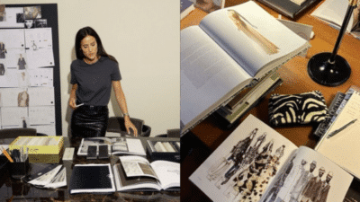 Fashion designer reviewing fabric samples and sketches with open books and style boards in a creative workspace.