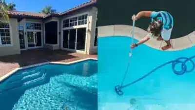 Backyard pool next to a house, with a person cleaning a pool on the right. Sunny day highlighting the clear blue water.
