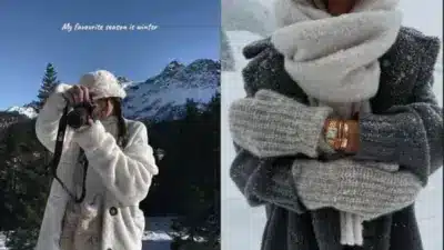 Person in cozy winter attire, taking photos and standing in snowy mountains, highlighting winter fashion and scenic landscapes.