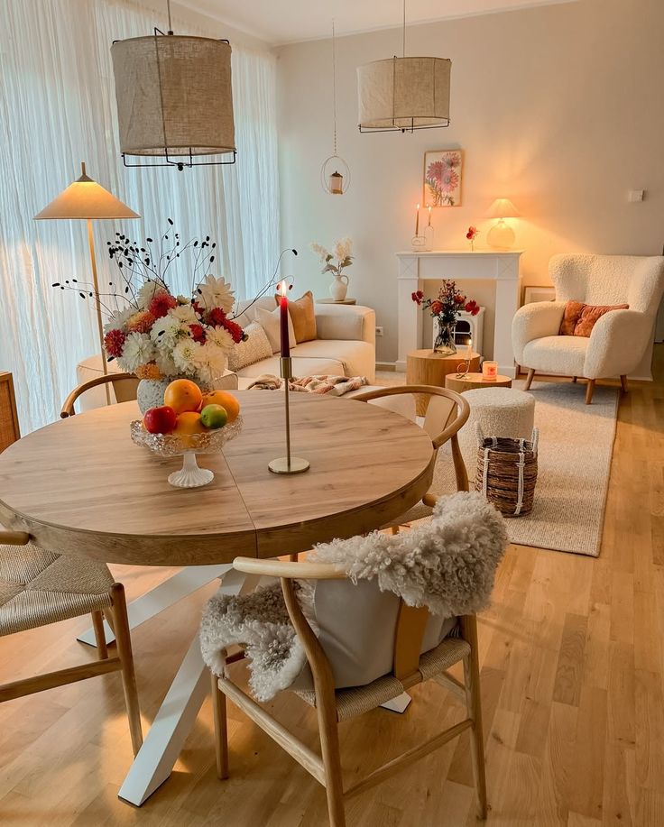 Warm Cozy Living Dreams 🕯️✨ Cozy living room with a wooden round table, flowers, candles, and comfortable chairs, creating a warm and inviting ambiance. | Sky Rye Design Cozy living room with a wooden round table, flowers, candles, and comfortable chairs, creating a warm and inviting ambiance.