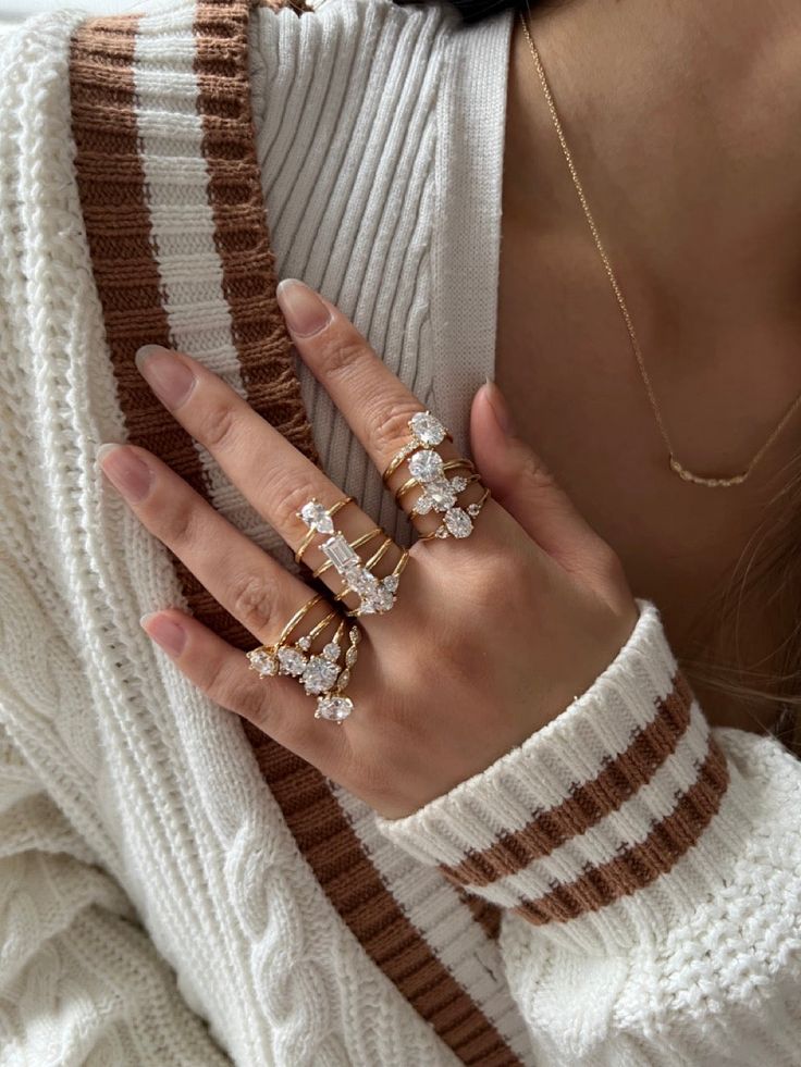Your destination for learning and getting jewelry- inspired Elegant stack of gold rings with diamonds on hand, paired with a cozy knitted sweater, showcasing fashionable jewelry style. | Sky Rye Design Elegant stack of gold rings with diamonds on hand, paired with a cozy knitted sweater, showcasing fashionable jewelry style.