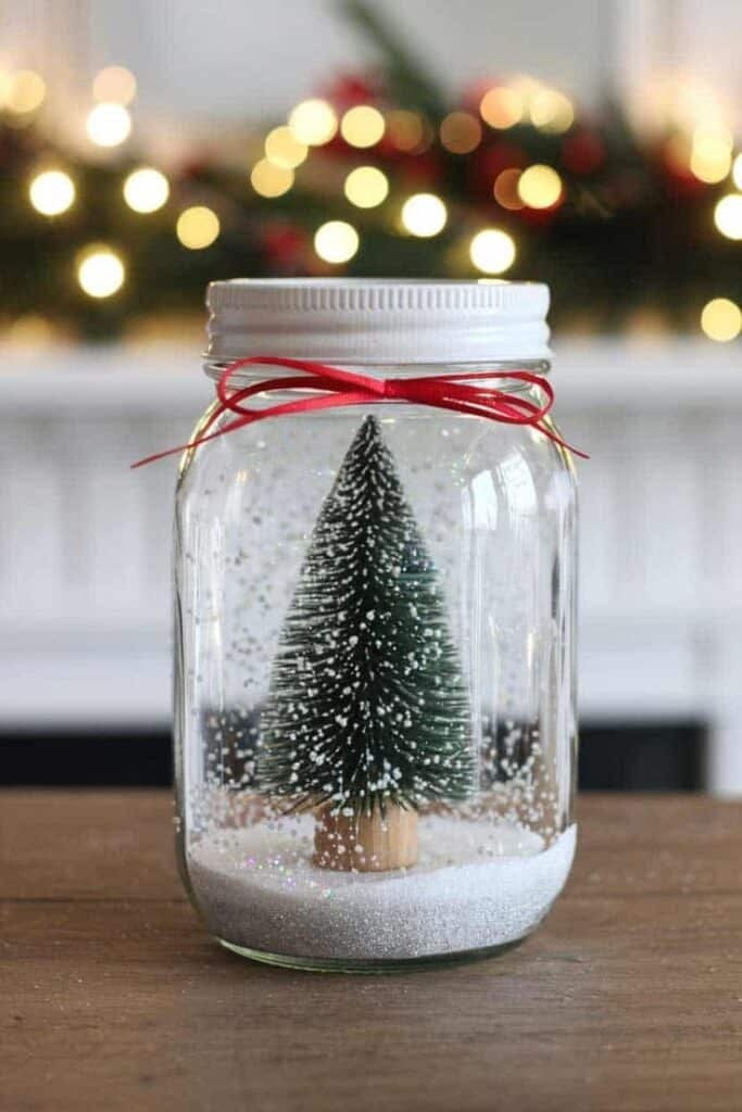 a0268fb842997d8b33e8a28eb29fb3ee Miniature Christmas tree in a jar with snow, adorned with a red ribbon, festive lights in background. Cozy holiday decor idea. | Sky Rye Design Miniature Christmas tree in a jar with snow, adorned with a red ribbon, festive lights in background. Cozy holiday decor idea.