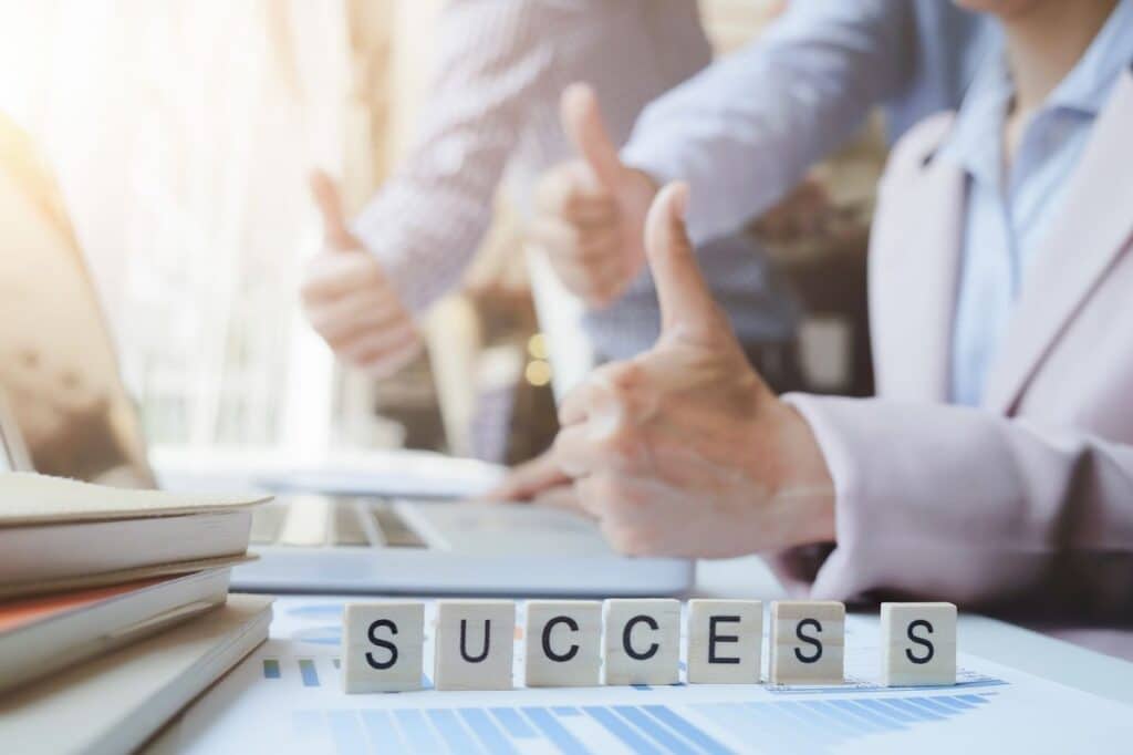 a9ca1c5247752ccf3f46358e8f9232c5 Blocks spelling SUCCESS with a blurred office background, featuring three people giving thumbs up, symbolizing achievement and positivity. | Sky Rye Design Blocks spelling SUCCESS with a blurred office background, featuring three people giving thumbs up, symbolizing achievement and positivity.