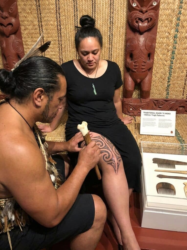 ai-photo-studio-1765816588562-2 Traditional Māori tā moko tattooing in progress, showcasing intricate leg design and historical cultural practice. | Sky Rye Design Traditional Māori tā moko tattooing in progress, showcasing intricate leg design and historical cultural practice.