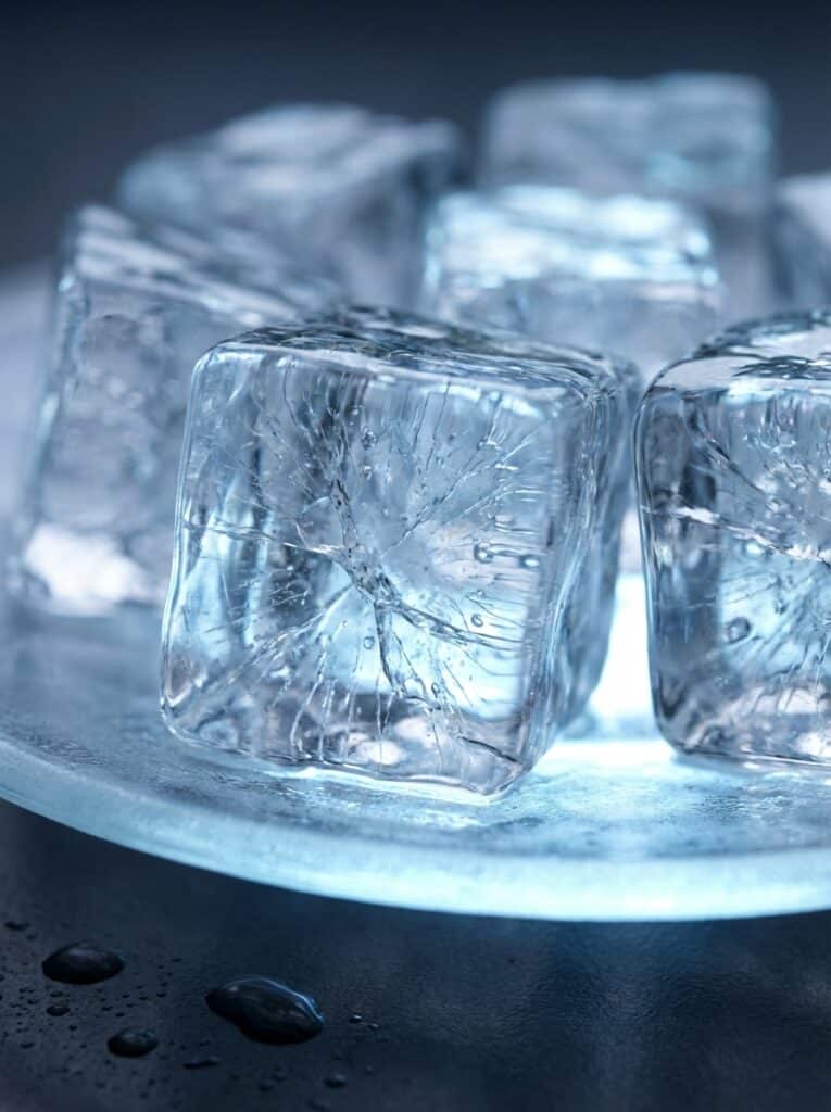ai-photo-studio-1766413768229-1 Close-up of clear ice cubes on a frosty surface, with water droplets, highlighting their transparency and refreshing coolness. | Sky Rye Design Close-up of clear ice cubes on a frosty surface, with water droplets, highlighting their transparency and refreshing coolness.