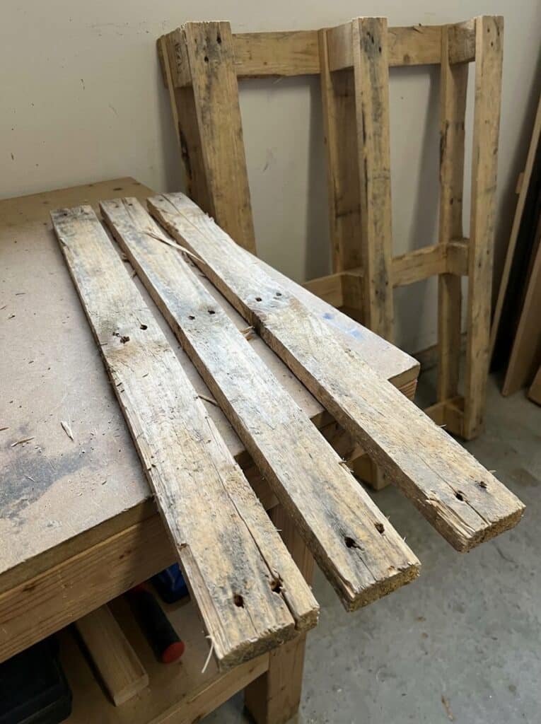 ai-photo-studio-1766515690286-1 Old wooden pallet boards on a workbench, ideal for DIY projects or recycling into creative furniture pieces. | Sky Rye Design Old wooden pallet boards on a workbench, ideal for DIY projects or recycling into creative furniture pieces.