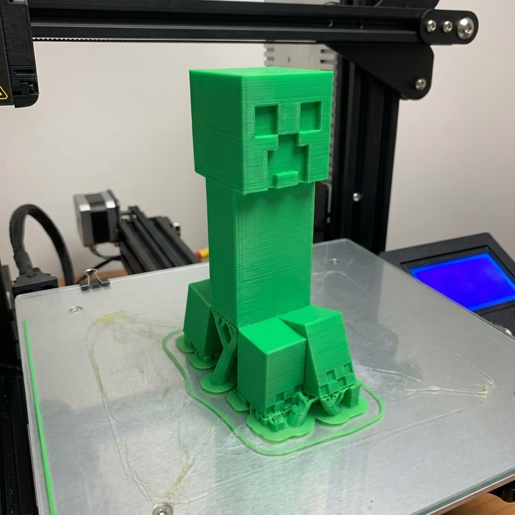ai-photo-studio-1766594201253-1 3D printed green blocky character on a printer bed, showcasing detailed design and precise printing process. | Sky Rye Design 3D printed green blocky character on a printer bed, showcasing detailed design and precise printing process.