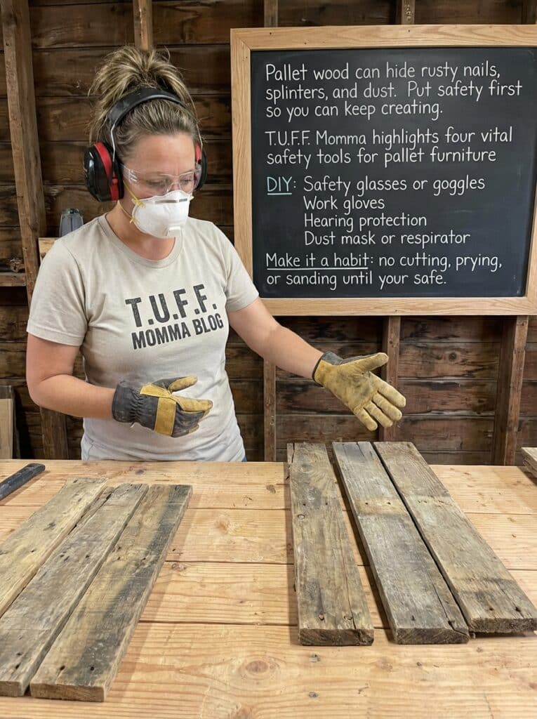 ai-photo-studio-1766940140175-2 Woman preparing pallet wood with safety gear in workshop; chalkboard lists DIY safety tools for pallet furniture projects. | Sky Rye Design Woman preparing pallet wood with safety gear in workshop; chalkboard lists DIY safety tools for pallet furniture projects.