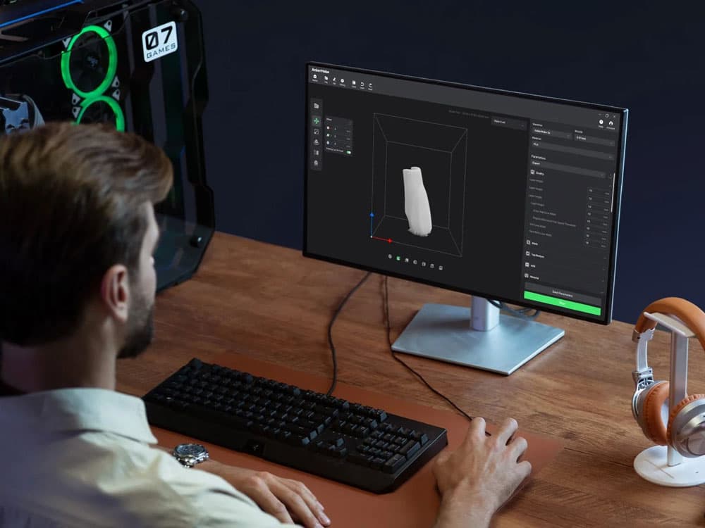 ankermake-slicer-3d Man using 3D modeling software on desktop computer, gaming PC visible, headphones on desk for creative design in tech workspace. | Sky Rye Design Man using 3D modeling software on desktop computer, gaming PC visible, headphones on desk for creative design in tech workspace.
